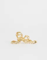 Broche dorado para el pelo con forma de moño.