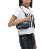 Bolso de hombro Marc Jacobs modelo The Rip and Repair Denim Clover, confeccionado en denim azul desgastado con detalles en cuero negro. Cuenta con cierre magnético, logo JMarc revestido, correa de cuero extraíble y correa de cadena cruzada.