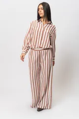 Pantalón de corte palazzo, color marrón con rayas verticales blancas, confeccionado en simil lino y con bolsillos laterales.
