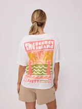 Remera negra de algodón con corte holgado y estampado frontal con el texto "Rusty Australia Mermaid Beach" en colores naranja, verde y amarillo.