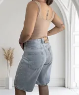 Musculosa ajustada de tejido acanalado (morley), con escote redondo y bordes ondulados en el ruedo. Disponible en colores beige, blanco y negro.