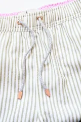 Short de baño a rayas verticales color beige y blanco, con cintura elástica ajustable con cordón, bolsillos laterales y trasero con cierre, y logo bordado en la pierna.