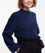 Suéter corto azul marino de punto liviano, con cuello alto, manga larga y puños ajustados.