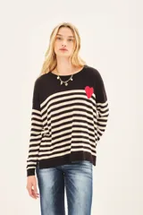 Sweater de punto a rayas horizontales en blanco y negro, con detalle de corazón rojo en el pecho.