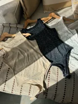 Body sin mangas color beige claro, ajustado al cuerpo, con cuello redondo y cubierto de apliques brillantes.