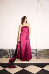 Vestido strapless de tafeta color magenta y negro, con corte holgado, largo midi, bolsillos laterales y pieza bicolor desmontable.