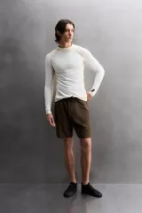 Camiseta de surf compresiva slim fit confeccionada en tejido técnico muy elástico y ligero. Con factor de protección ultravioleta 40+, cuello subido, manga larga, costuras planas y acabados combinados a contraste.