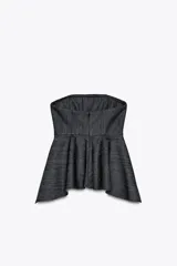 Top strapless de denim color azul oscuro, con corte recto y bajo asimétrico. Cierre con cremallera oculta en la costura.