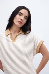 Remera con cuello tipo polo y escote en V, a rayas horizontales color beige y blanco, con cuello y mangas color beige liso.