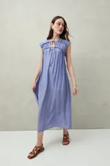 Vestido largo lila con escote con lazo, mangas cortas y frunces en el pecho.