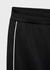 Pantalón negro de corte recto con cintura elástica, tiro medio y detalle de raya blanca lateral. Estilo jogger y diseño largo.
