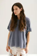 Remera azul de corte holgado con mangas cortas y costuras a la vista en color blanco.