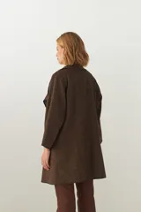 Tapado marrón de largo medio, abierto, con cuello y envivado. Hecho 100% en Uruguay con tela 100% lana fina sin teñir, diseñada exclusivamente por Don Baez.