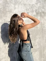 Top negro de ecocuero con cuello halter y espalda descubierta.
