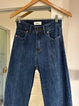 Pantalón de jean azul oscuro, de corte ancho y tiro alto, con bolsillos delanteros y traseros.