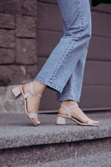 Sandalias de tacón bajo color beige con textura símil piel de serpiente. Tienen una tira delgada sobre los dedos y una pulsera con hebilla al tobillo.