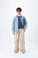 Pantalón cargo color beige, de corte recto y holgado, con cintura elástica y bolsillos laterales con solapa.