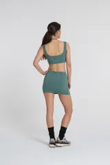 Minifalda deportiva color verde azulado, confeccionada en tejido Activelu con compresión media, cintura alta y protección UV50+.