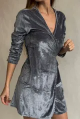 Vestido corto gris de terciopelo, con escote cruzado en V y mangas largas con puños fruncidos.
