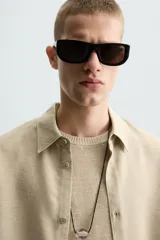 Camisa de manga larga color celeste claro, con cuello solapa y cierre frontal de botonadura. Presenta una textura sutil en el tejido.