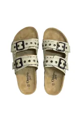 Sandalias de cuero sintético color crudo, con dos tiras con hebillas metálicas ajustables y plantilla anatómica.