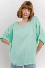 Blusa color beige confeccionada en lino, de corte holgado, mangas 3/4 y cuello redondo.