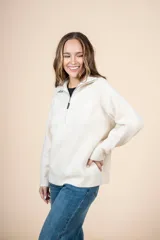 Cardigan color crudo de tejido de punto acanalado, con cuello alto y cierre frontal parcial con cremallera metálica. De corte oversize, mangas largas y puños ajustados.