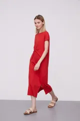 Vestido midi rojo de corte recto con mangas cortas y detalle de nudo en la parte delantera.