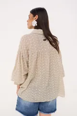 Camisa celeste a rayas verticales blancas, con cuello clásico, cierre frontal con botones y mangas largas abullonadas con puños elásticos.