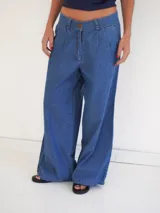 Pantalón de denim celeste de corte amplio, con bolsillos laterales y botón de nácar.