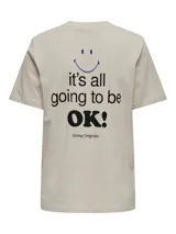 Remera color crema de algodón orgánico con cuello redondo y mangas cortas. Estampado frontal con una carita sonriente azul y la frase "it's all going to be OK!" en negro.
