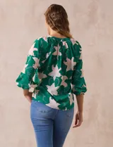 Blusa de gasa estampada marca Sioni, con cuello a la base y escote en V. Tiene mangas 3/4 con terminación fruncida.