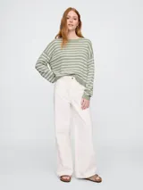 Sweater de punto color verde claro con rayas horizontales blancas, de corte holgado y cuello redondo.