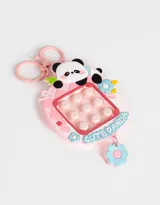 Llavero con charm de panda sobre un pop it antiestrés de color rosa, celeste y blanco.