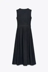 Vestido midi de denim azul oscuro, sin mangas, con cuello redondo, bolsillos laterales, cinturón con hebilla metálica y cierre frontal con cremallera.
