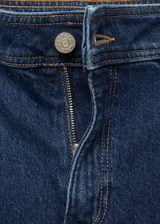 Pantalón de jean azul oscuro, corte culotte, tiro alto, con cierre de cremallera y botón, trabillas, bolsillos traseros y bajo deshilachado.
