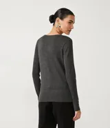 Suéter de punto color verde, con cuello barco, mangas largas y textura acanalada.