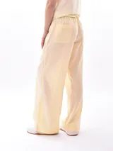 Pantalón de lino color amarillo pastel, de corte recto y tiro alto, con cintura elástica ajustable con cordón.