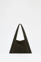 Bolso tipo tote de hombro en cuero serraje color marrón oscuro con tachas metálicas doradas en el cuerpo y las asas. Tiene bolsillo interior y cierre con botón imantado.