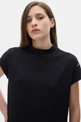 Blusa negra de rib con cuello subido y mangas cortas.