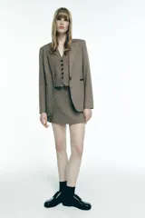 Chaleco de Zara Woman Collection con escote pico y sisa. Tiene falsos bolsillos de vivo en el delantero, tejido combinado a contraste en la espalda y cierre frontal con botones.