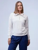 Buzo de algodón color beige, con cuello con solapa y cierre frontal metálico, manga larga y diseño cómodo.