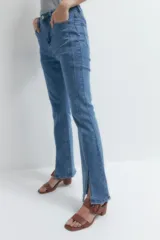 Pantalón de jean de tiro alto, corte ajustado y botamanga acampanada con tajos laterales.