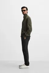 Pantalón chino azul marino, corte skinny fit, confeccionado en tejido de algodón con elasticidad. Cuenta con bolsillos frontales y traseros de vivo. Cierre frontal con cremallera y botón.