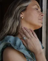 Aros pequeños de bronce con forma irregular y acabado liso, estilo huggie o argolla gruesa.