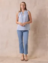 Blusa sin mangas color beige con rayas verticales finas, cuello redondo fruncido con escote en V y lazo con borlas.