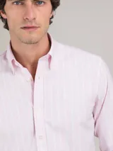 Camisa de hombre de corte regular fit, confeccionada en tejido oxford a rayas verticales celestes y blancas. Tiene cuello button-down, cierre con botones, manga larga con puño simple y logo bordado en el pecho.