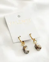 Aros colgantes con aro dorado y dije de piedra sintética color crema con vetas marrones.