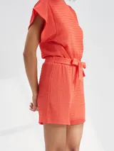 Short color rojo con textura arrugada y lazo en la cintura.