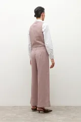 Pantalón de tiro alto, corte ancho y largo, con estampado de pata de gallo pequeño en tonos beige y rosado/marrón. Presenta bolsillos delanteros con solapa.